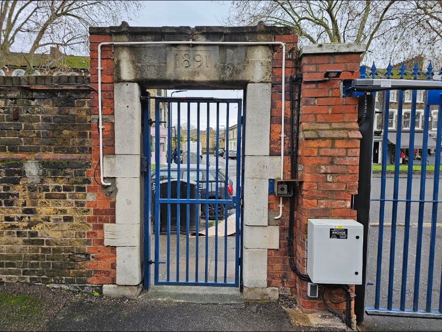 Stone gateway before cleaning, showing staining and growth