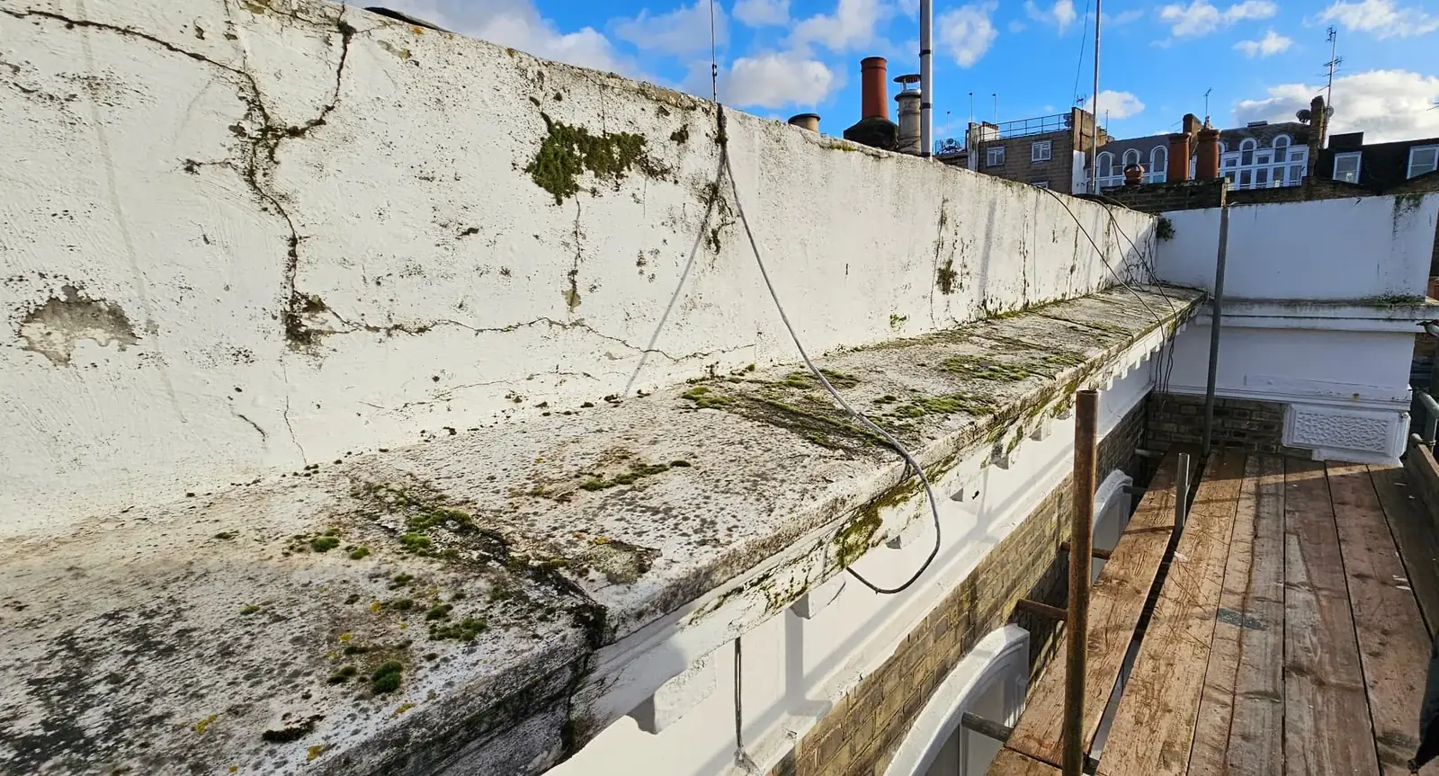 Soiled and cracked stucco cornice and parapet before works at Sunningdale Gardens