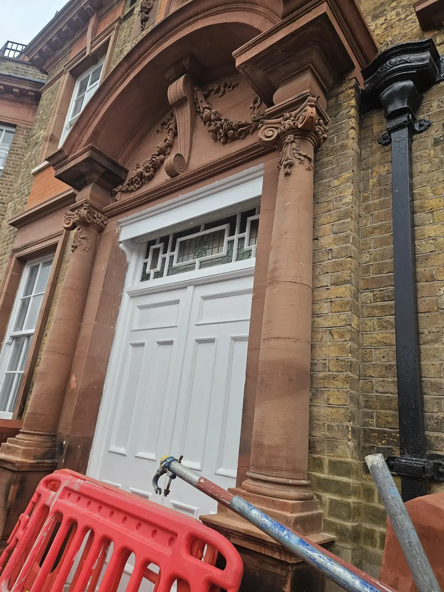 Restored sandstone entrance pillars, carved capitals and decorative pediment at Richmond Royal Hospital