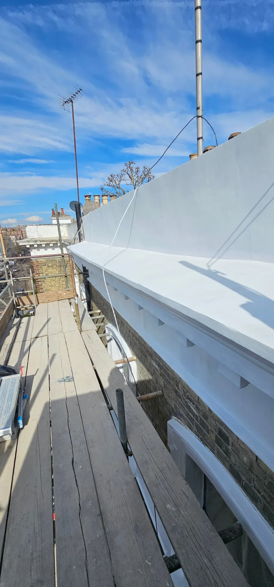 Renewed stucco cornice and coping running the length of the roofline at Sunningdale Gardens